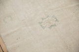 Texture of the evenly worn pile showing exposed knot heads and a pale teal medallion detail.