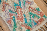 Plush hand-knotted pile, side cord selvage, and braided fringe on a Moroccan rug corner.