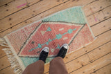 A person standing on a plush Moroccan rug shows the scale of its geometric diamond design.