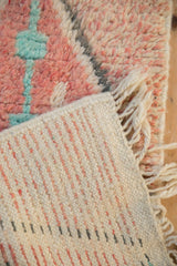 Detail of a Moroccan rug's hand-knotted back, plush pile, and ivory wool fringe.