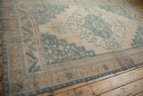 Detailed view of the corner spandrel and worn palmette border of a vintage Oushak rug.