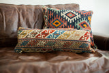 Unique Caucasian Accent Pillow with antique geometric patterns in rich red, blue, and cream.