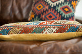 Colorful geometric pattern of the long Caucasian pillow with mustard yellow velvet side.