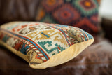 Detailed view of the antique Caucasian pillow's hand-knotted geometric pattern and mustard velvet side.