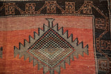 Distressed vintage Kurd rug detail, serrated diamond motif, geometric main border, dusty rust field.