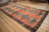 Distressed Kurd runner detail: tribal serrated diamond motif and geometric relief border.