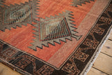 Distressed Kurd runner detail: dusty rust field with faint foundation, serrated diamond, geometric border.