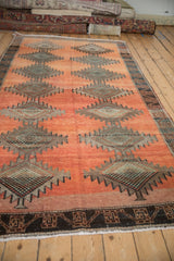 Vintage distressed Kurd runner with faded terracotta field, serrated diamonds, and geometric border.