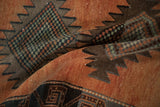 Distressed Kurd runner detail showing serrated diamond motifs, checkered infill, faded rust, charcoal, and soft green hues.