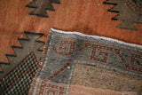 Distressed vintage Kurd runner with hand-knotted foundation, geometric motifs, and muted rusty pile.