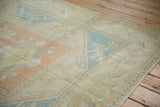 Distressed vintage Dosemealti rug with dusty rose, pale blue florals, and visible foundation.