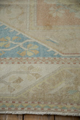 Distressed vintage Dosemealti carpet detail with pale blue geometric and soft beige floral motifs.