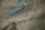 Worn texture of a vintage Dosemealti rug, with faded sky blue and dusty rose patterns.