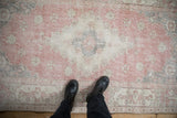 Distressed Sparta rug showing faded pink and ivory floral patterns with visible foundation.