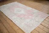 Distressed vintage Sparta rug corner with faded pink, ivory, and grey Samovar Turtle border.
