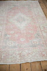 Distressed vintage Turkish Sparta rug with soft pink, ivory, and faded floral texture.