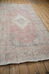 Distressed texture of vintage Sparta rug with pink, ivory, and oxidized silver floral motifs.