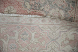 Distressed pink and ivory pile, fringe, and hand-knotted foundation of the vintage Sparta rug.