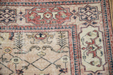 Vintage distressed Sparta rug corner, featuring dusty cherry red Samovar Turtle border and beige floral lattice.