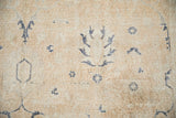 Distressed vintage Sparta rug, visible foundation and dusty navy floral lattice pattern.