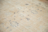 Distressed vintage Sparta rug texture with worn navy floral patterns on dusty sandalwood.