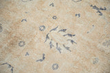 Distressed Sparta rug pile showing worn sandalwood and ivory with navy floral elements.