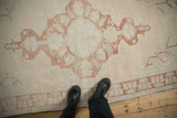 Distressed vintage Oushak rug texture with soft ivory, copper, and pale blue motifs.
