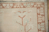 Distressed Oushak runner corner with ivory low pile, pale copper plant border, and pale blue motifs.