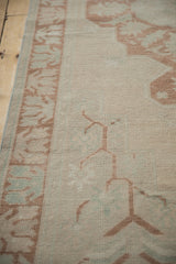 Distressed Oushak runner border showing germinating plant motif in pale copper and ivory.