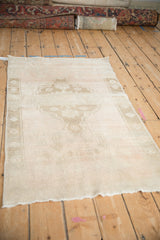 Distressed Oushak rug showing heavy abrashes and an oversize faded floral medallion.