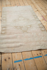 Textured, distressed pile and machine-bound end of a vintage Oushak rug.