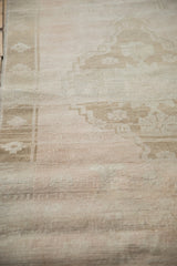 Distressed vintage Oushak rug, heavy wear, faint foundation, and soft ivory shades.