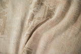Textured pile of a vintage distressed Oushak rug, showing heavy abrash and faint floral design.