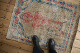 Distressed vintage Sparta pictorial rug underfoot, showing its worn, low-pile texture and scale.