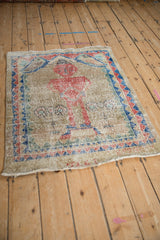 Angled view showing the heavy wear and faded pictorial design on a vintage Sparta rug.