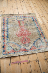 Angled view of a distressed vintage Sparta rug showcasing its pictorial design and faded colors.