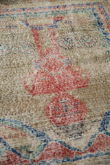 Close-up on the worn hand-knotted texture of a pictorial Sparta rug showing its foundation.