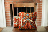 Vintage Persian rug pillow in red with a blue, tan, and ivory geometric floral pattern.