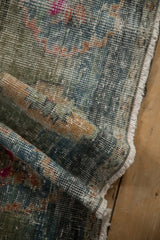Distressed vintage Oushak rug showing worn pile, blues, greens, magenta, fringe, and foundation.