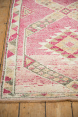 Close-up of the playful triangle border with alternating colors on a distressed pink rug.