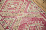 Textured low pile and heavy abrash on a distressed Kurd rug with magenta and ivory geometric medallions.