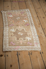 Angled view of a vintage Kars rug mat showing its geometric double medallion and short, even pile.