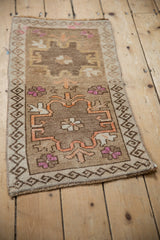 Angled view of a vintage Kars mat showing its geometric medallions and distressed, low-pile texture.