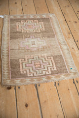Geometric hook and latch medallion detail with faded pastels on a distressed Kars rug.