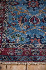 Meandering vine and floral motifs on the plush, sky blue pile of a vintage Bibikabad rug corner.
