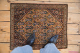 A personal scale view of a vintage Sarouk rug with a saffron field and repeating blue paisley boteh.