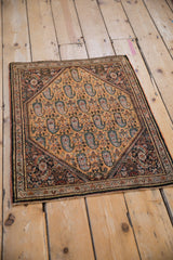 Angled view of a vintage Sarouk rug, showing its dense paisley boteh field and detailed corner spandrels.