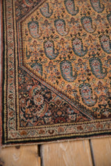 Corner of a vintage Sarouk rug featuring the dark Herati spandrel and paisley boteh field.