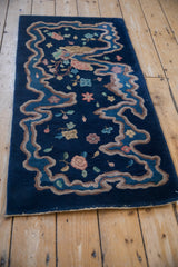 Art Deco rug close-up: curvilinear sky blue river border, pale coffee, dusty rose blossoms.
