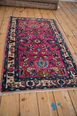 Vintage Lilihan rug corner detail, highlighting magenta field and indigo, beige floral border.